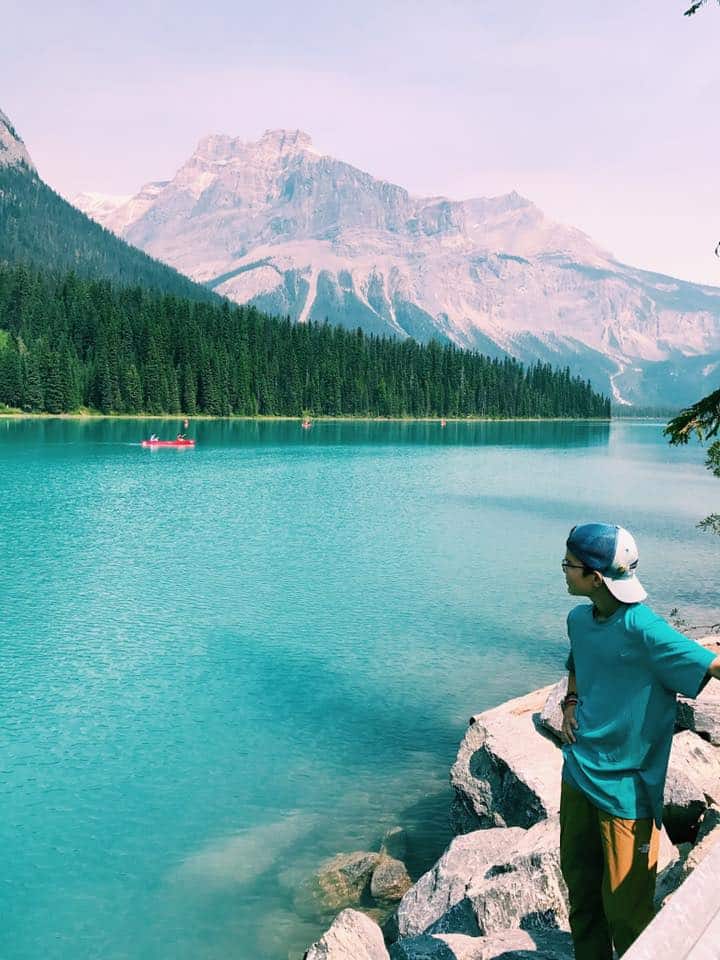 Young teenager standing on the edge of Lake Louise