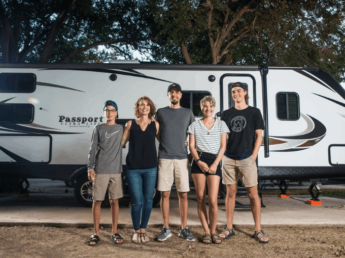 Family of five in front of travel trailer RV