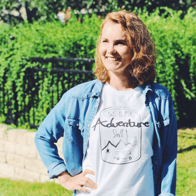 Woman smiling wearing white tee shirt with words Adventure