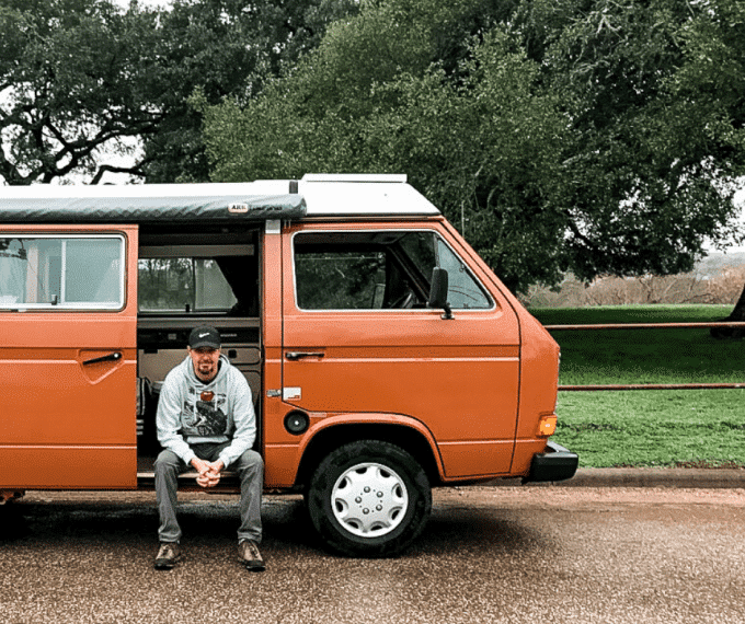 Man sitting in doorway of camper van