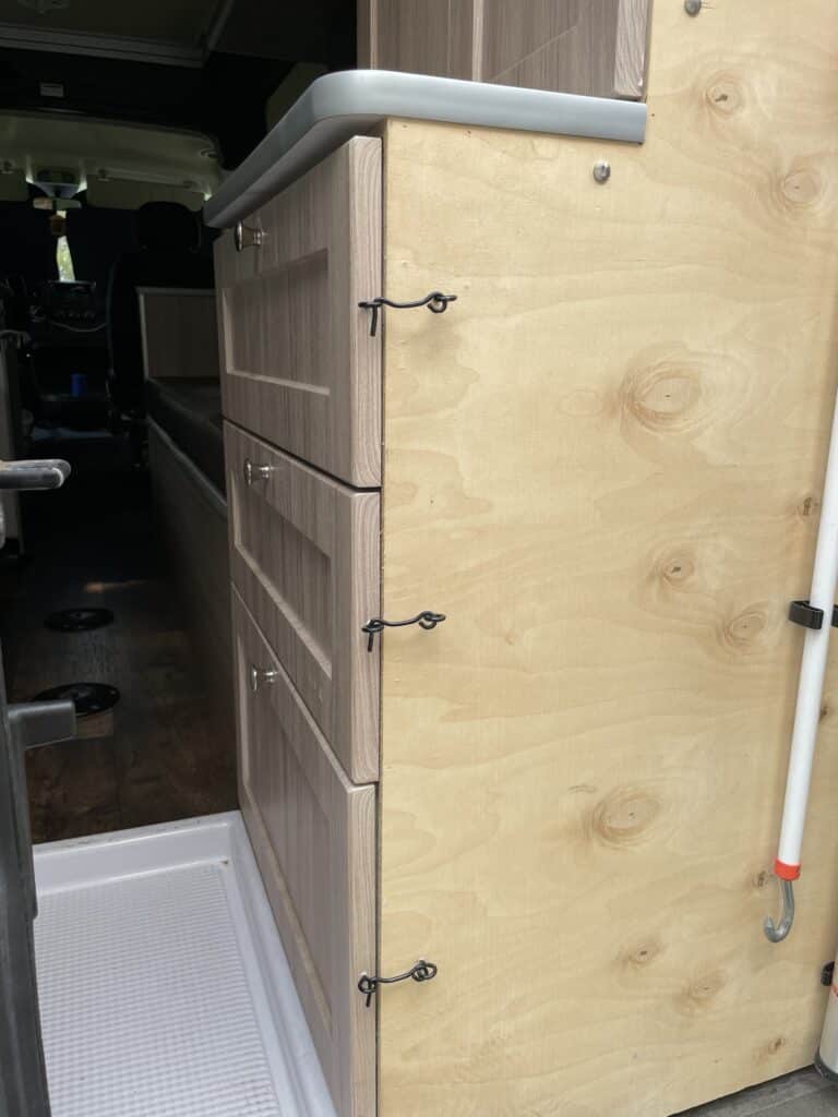 Hook and eye latches installed on drawers inside camper van