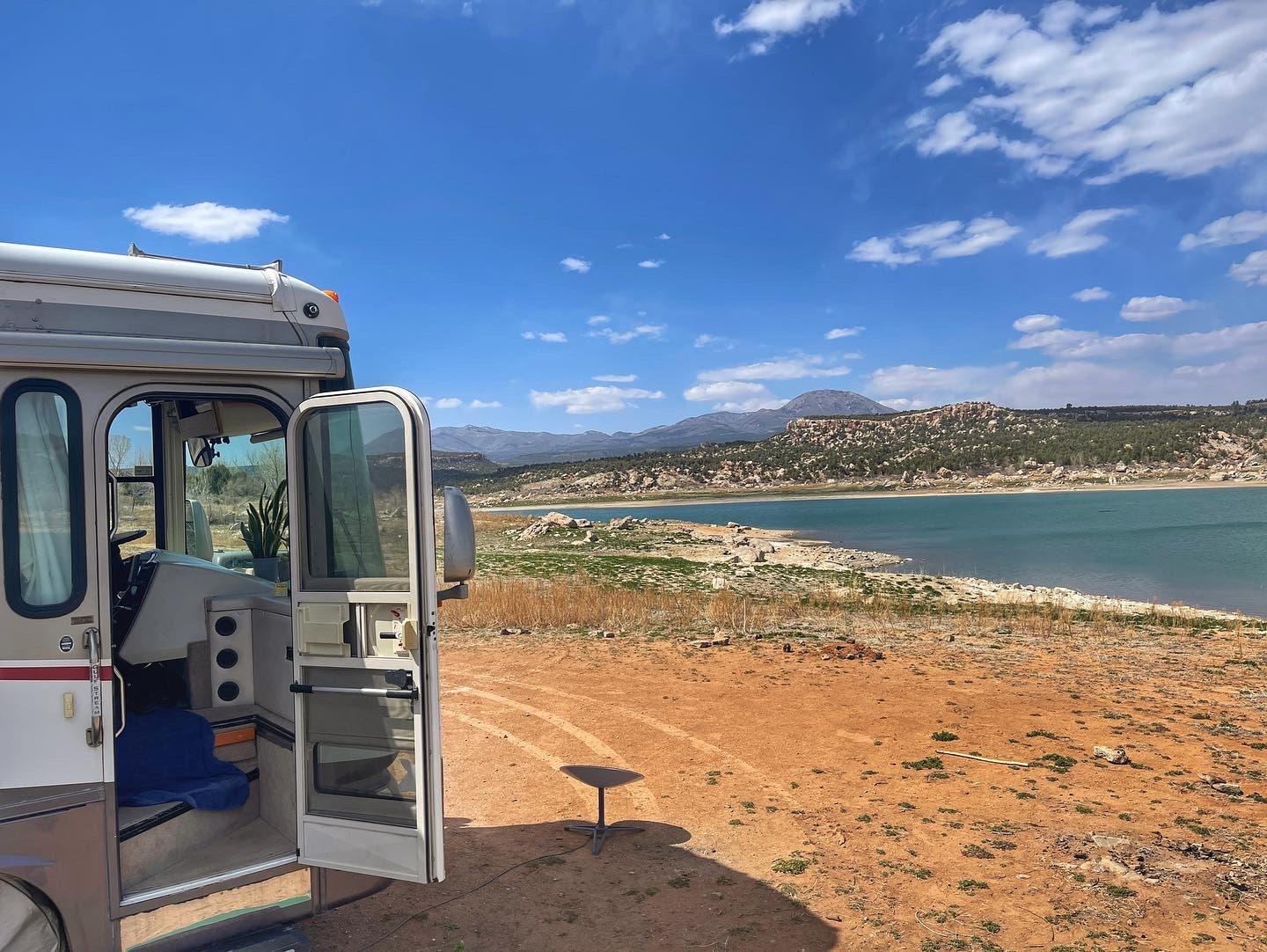 RV with door open parked near river
