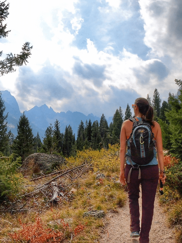 Woman with daypack hiking on trail