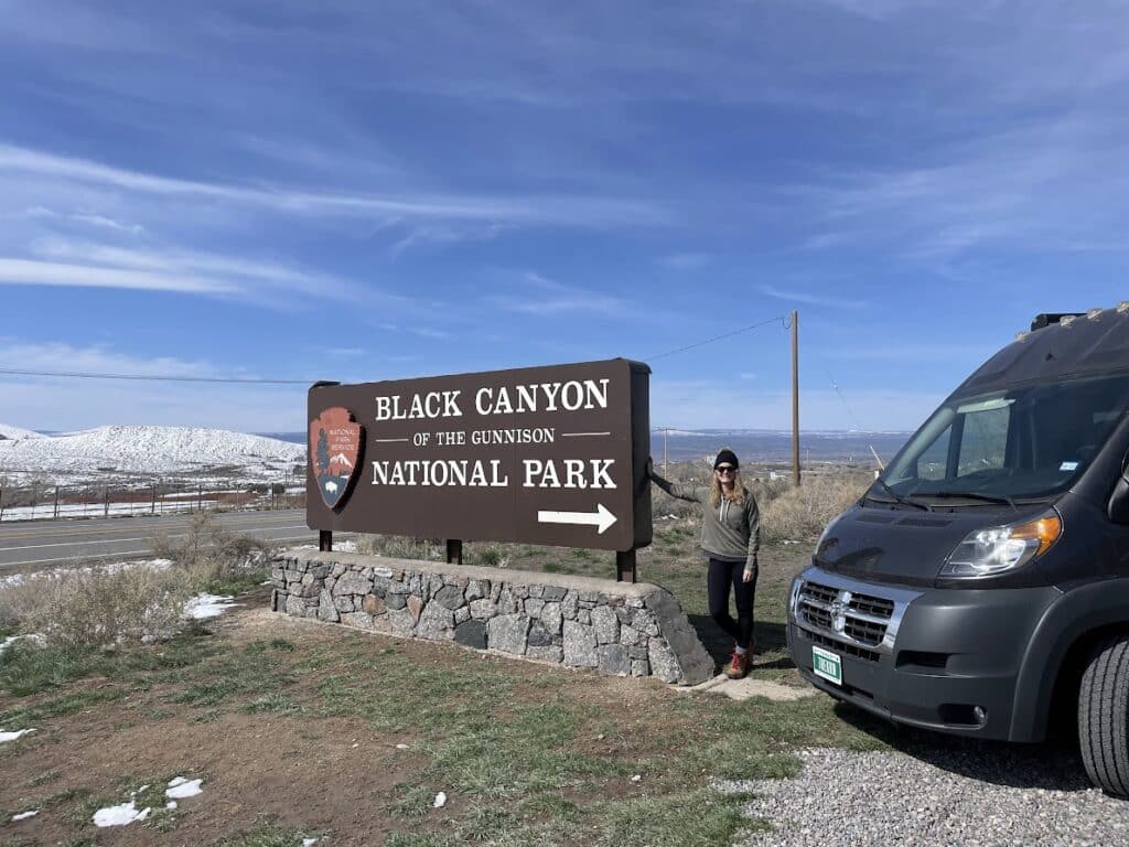 Woman and Campervan at entrance of Black Canyon National Park